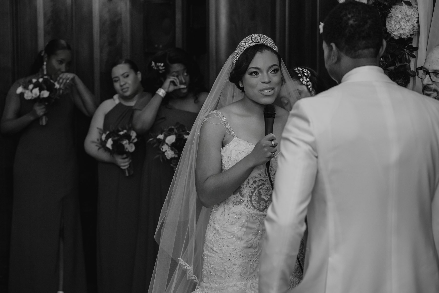 Bride speaking into a microphone to the groom during the reception