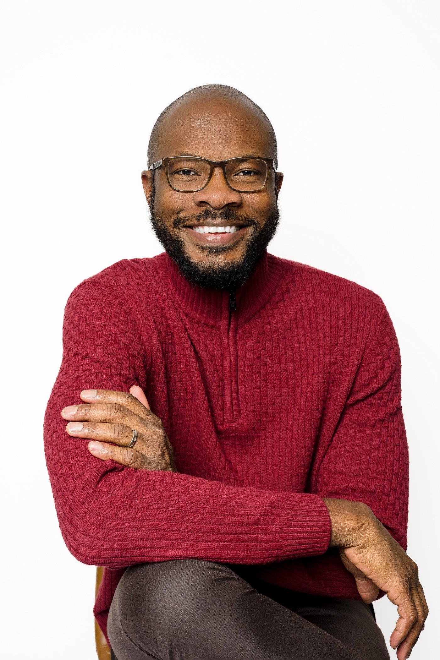 Tiem Okori, wedding photographer, smiling in a red sweater