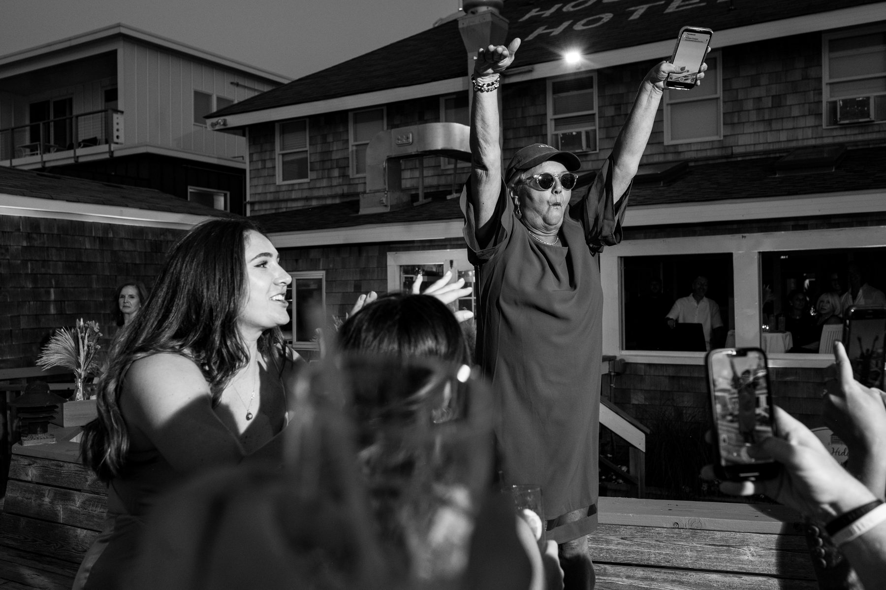 Black and white photo of guests dancing and celebrating outdoors